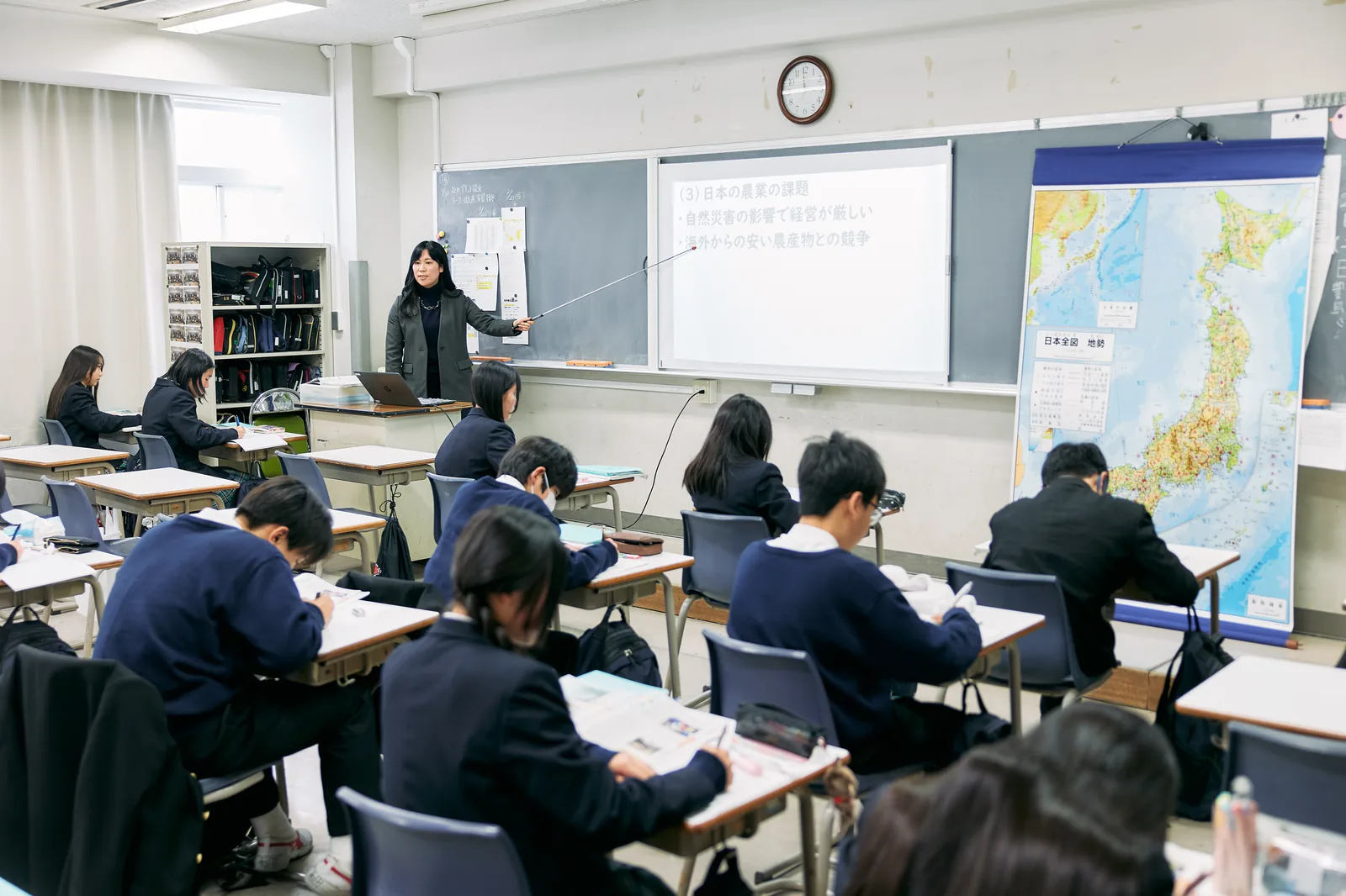 獨協埼玉中学高等学校の社会の授業。教室の前で教員が日本全図を指し、生徒が席に着いている